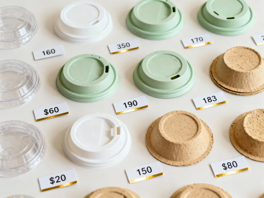 Diverse paper cup lids with pricing details.